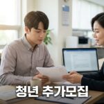 고용센터 상담 창구에서 서류를 살펴보는 청년과 상담사